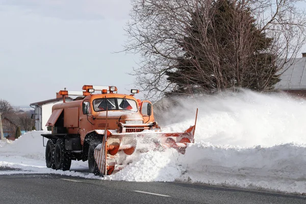 一辆有犁的大车把道路从雪中清理干净 橙色货物专用设备在冬季与元素作斗争 消除雪灾的影响 交通困难 冷冻水 — 图库照片