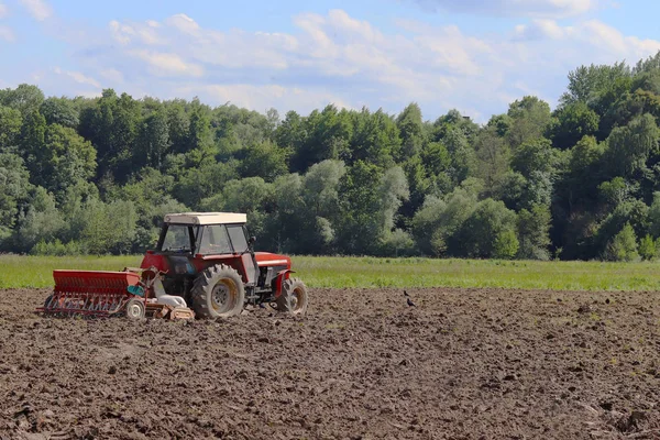 Seorang Petani Traktor Merah Dengan Seeder Menabur Biji Bijian Tanah — Stok Foto