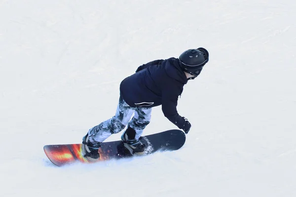 スノーボーダーはスキー場で雪に覆われた斜面を下るスノーボードに乗って 冬のスポーツ フリー スタイル スラローム系 極端な寒さのための機器 寒さの中の健康のための活動です 若者の趣味 — ストック写真