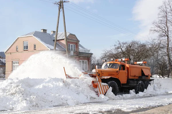 一辆有犁的大车把道路从雪中清理干净 橙色货物专用设备在冬季与元素作斗争 消除雪灾的影响 交通困难 冷冻水 — 图库照片