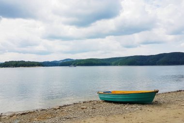 Tekne gölün kumlu sahilde demirleme demirleme. Tesis ve rekreasyon insan suya yakın. Tatil ve seyahat doğada. Ekoloji çevre. Taze su ortamında ve balıkçılık.
