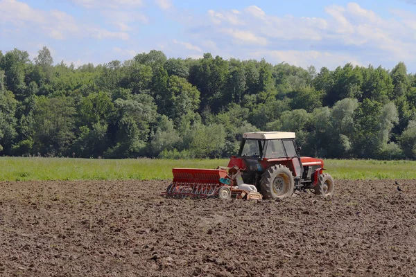 Seorang Petani Traktor Merah Dengan Seeder Menabur Biji Bijian Tanah — Stok Foto