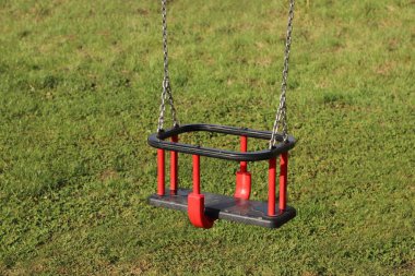 Bir çocuk zincirinin plastik koltuk salıncak dünya askıya alınmış. Uyarlamalar için bir oyun alanı. Neşeli ve kaygısız bir yaşam anıları. Bir metal zincir kullanın. Üretimi kadar büyüyen faaliyet.