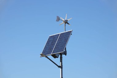 Rüzgar jeneratörü ve güneş paneli üzerindeki mavi gökyüzü. Fotovoltaik hücreler. Alternatif enerji elde etme yöntemi. Ekolojik elektrik temiz. Yüksek teknoloji elektronik. Enerji bağımsızlığı.