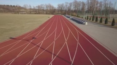 Kırmızı koşu parkuru stadyum boyunca yayılır. Bir spor kompleksi unsuru havadan çekim video. Açık spor için kaplama. Yer yüksekliği ile atletizm yarışmaları için bir 