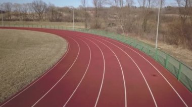 Kırmızı koşu parkuru stadyum boyunca yayılır. Bir spor kompleksi unsuru havadan çekim video. Açık spor için kaplama. Yer yüksekliği ile atletizm yarışmaları için bir 