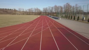 Kırmızı koşu parkuru stadyum boyunca yayılır. Bir spor kompleksi unsuru havadan çekim video. Açık spor için kaplama. Yer yüksekliği ile atletizm yarışmaları için bir 