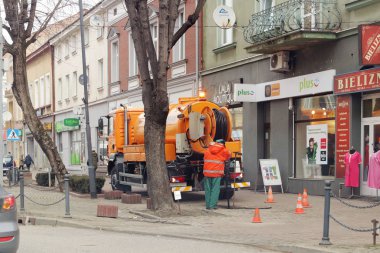 Jaslo, Polonya - 3 9 2019: Belediye Servisi çalışanları bir vakum varil ile bir araba kullanarak şehir kanalizasyon kir pompalanır. Kentsel atık ağlar onarın. Ekoloji şehirler ve sokakları Temizleme