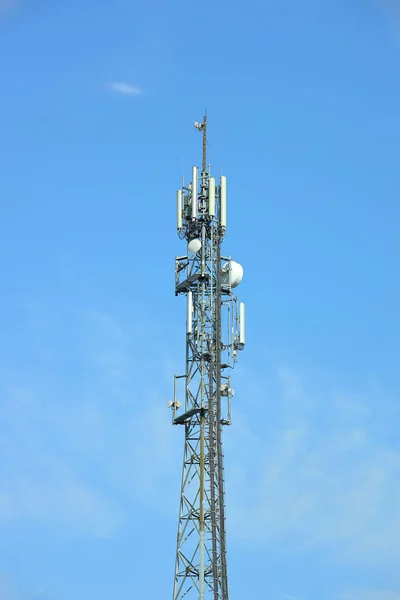 Radio tower with antennas on a blue sky background. Metal construction. Wireless network. Transmit tv radio signal. Egology of the environment. Information digitalization and high technology — Stock Photo, Image