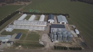 Yeşil tepelik alanlar arasında yer alan büyük bir çiftlik yüksekliğini görünümden. Bir uçak veya bir quadro videodan. Paslanmaz çelik silo ile Agro-endüstriyel kompleks. Organik gıda üretimi. Süt sanayî için