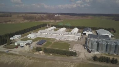 Yeşil tepelik alanlar arasında yer alan büyük bir çiftlik yüksekliğini görünümden. Bir uçak veya bir quadro videodan. Paslanmaz çelik silo ile Agro-endüstriyel kompleks. Organik gıda üretimi. Süt sanayî için