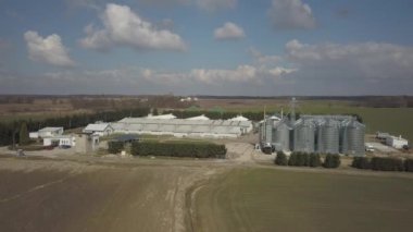 Yeşil tepelik alanlar arasında yer alan büyük bir çiftlik yüksekliğini görünümden. Bir uçak veya bir quadro videodan. Paslanmaz çelik silo ile Agro-endüstriyel kompleks. Organik gıda üretimi. Süt sanayî için