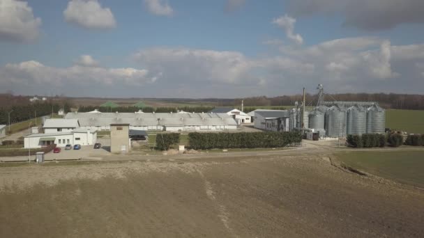 从位于绿色丘陵地带之间的一个大型农场的高度可以看到 无人机或四人组的视频 带不锈钢筒仓的农工综合体 有机食品生产 乳品行业 — 图库视频影像