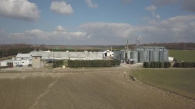 Yeşil tepelik alanlar arasında yer alan büyük bir çiftlik yüksekliğini görünümden. Bir uçak veya bir quadro videodan. Paslanmaz çelik silo ile Agro-endüstriyel kompleks. Organik gıda üretimi. Süt sanayî için