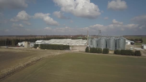 从位于绿色丘陵地带之间的一个大型农场的高度可以看到 无人机或四人组的视频 带不锈钢筒仓的农工综合体 有机食品生产 乳品行业 — 图库视频影像