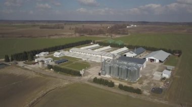 Yeşil tepelik alanlar arasında yer alan büyük bir çiftlik yüksekliğini görünümden. Bir uçak veya bir quadro videodan. Paslanmaz çelik silo ile Agro-endüstriyel kompleks. Organik gıda üretimi. Süt sanayî için