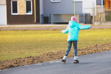 Bahar sezonu yeni bir asfalt yolda silindirler üzerinde Kız biniyor. Gençlik etkinliği ve sağlıklı bir yaşam tarzı. Spor eğitim ve rekabeti severler. Spor malzemeleri kullanımı. Zafer peşinde