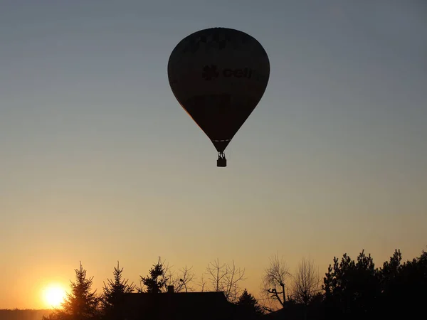 Vuelo en globo en los rayos del atardecer. El aire caliente llena la esfera y la eleva. Viaje de aventura por aire en un avión. Emoción y adrenalina de los valientes deportistas. Navigat —  Fotos de Stock