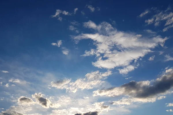 O sol brilha através das nuvens cumulus no céu azul. Contexto e textura para artistas e design. Luz brilhante nos olhos. Água em estado gasoso. A circulação de fluidos na natureza . — Fotografia de Stock