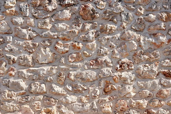 Antik Ortaçağ taş duvar. Doku duvar eski bir yapısının bir parçası. Tasarım ve yaratıcı çalışma için bir arka plan. Bina dış cephe süsleme ve dekorasyon. İnşaat işleri.