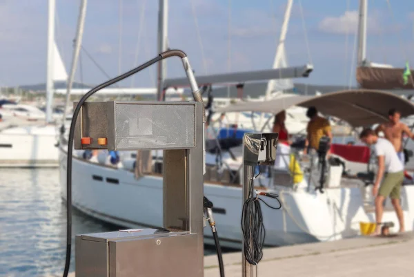 Паливний дистриб'ютор на пристані бензостанції в середземноморському Марині на тлі вітрильних яхт. Заправники човнів та рибальські човни. Інфраструктуру Адріатичного порту. Суботу — стокове фото