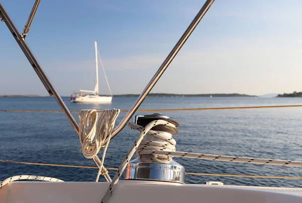 Skeleton winch on board a sailing cruise yacht. The view from the cockpit on the adjacent vessel at anchor. Quiet and calm morning yachting holiday. Boat charter in the nautical season on the sea — Stock Photo, Image