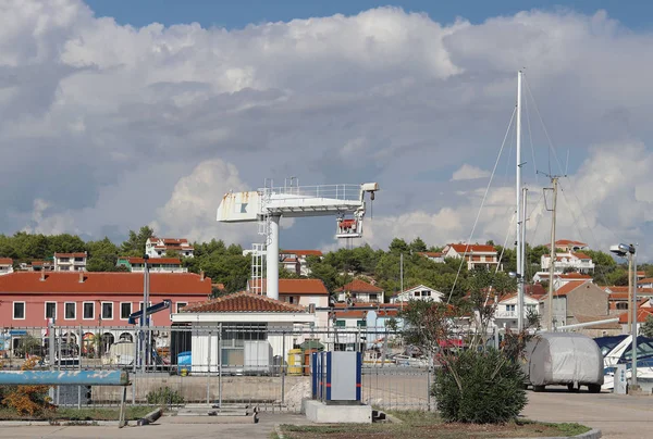 在克罗地亚的码头阿奇贾泽拉, 用于打捞船只的吊车电梯。在地中海地区亚得里亚海的达尔马提安伊迪翁。在一个阳光明媚、晴朗的日子里, 船只停泊在一个安静的渔城的港口 — 图库照片