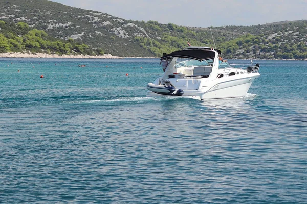 Компанія друзів на невеликому моторні яхти вітрилами уздовж берега біля невеликого Середземноморського містечка. Відпочинок на воді в раю. Круїз на чартерному човні на хорватській Рив'єрі. Далматинська Ісла — стокове фото