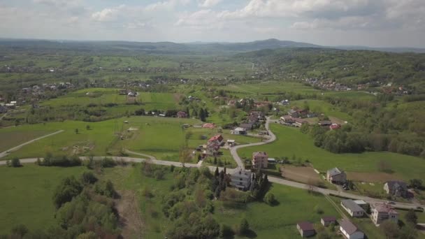 鳥瞰図から見たパノラマ 中央ヨーロッパ ポーランドの村は緑の丘と川の間に位置しています 温暖気候 フライトドローンまたはクワッドコプター 景観の都市化 — ストック動画