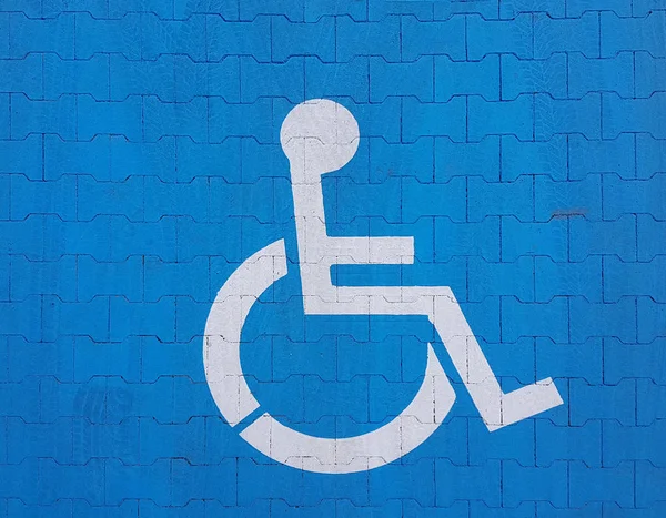 Σήμα σήμανσης δρόμου σε μπλε φόντο που υποδηλώνει χώρο στάθμευσης για ένα απενεργοποιημένο όχημα. Η ευκολία στάθμευσης ενός οχήματος. Το ταξίδι των ατόμων με αναπηρίες σε αναπηρικό καροτσάκι. Ελεύθερος χώρος για τους απόρους — Φωτογραφία Αρχείου