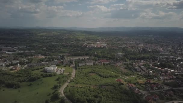鳥の視点からのパノラマ 中央ヨーロッパ 町や村は緑の丘の中に位置しています 温帯気候 工業地帯の飛行ドローンまたは四足歩行機 ポーランドのジャスロの町の近く — ストック動画