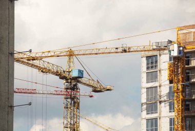 Kule vinçleri çok katlı bir binanın yapımı sırasında çalışır. Apartman sakinleri için yeni daireler ve ofisler için binalar. Yüksekken riskli iş. Ağır inşaat malzemeleri kaldırılıyor. Şehir Geliştirme