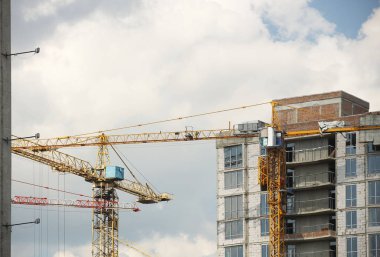 Kule vinçleri çok katlı bir binanın yapımı sırasında çalışır. Apartman sakinleri için yeni daireler ve ofisler için binalar. Yüksekken riskli iş. Ağır inşaat malzemeleri kaldırılıyor. Şehir Geliştirme