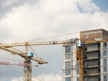 Kule vinçleri çok katlı bir binanın yapımı sırasında çalışır. Apartman sakinleri için yeni daireler ve ofisler için binalar. Yüksekken riskli iş. Ağır inşaat malzemeleri kaldırılıyor. Şehir Geliştirme