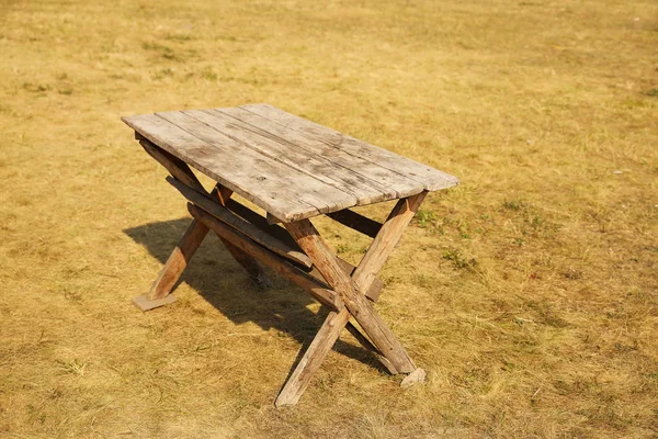 Uma mesa de madeira feita de tábuas antigas. Mobília estilizada em um estilo minimalista para um piquenique. O uso de madeira para a fabricação de móveis de jardim. Preparar para a carpintaria. Produtos de madeira ecológicos — Fotografia de Stock