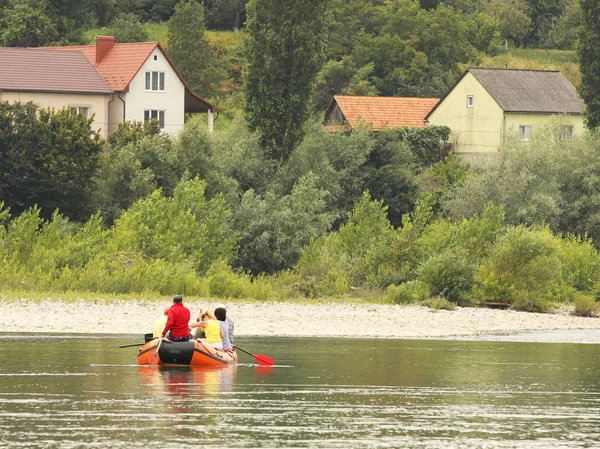 Un groupe de touristes faisant du rafting sur une rivière de montagne sur un ponton. Itinéraires touristiques de Transcarpathie en Ukraine. Rafting sur la rivière Tissa. Sécurité sur l'eau. Bateau de sauvetage et l'homme derrière le bot - MOB . — Photo