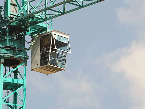 Gruas-torre trabalham durante a construção de um edifício de vários andares. Novos apartamentos para residentes e instalações para escritórios. Trabalho arriscado em altura. Levantamento de materiais de construção pesados. Desenvolvimento da cidade — Fotografia de Stock