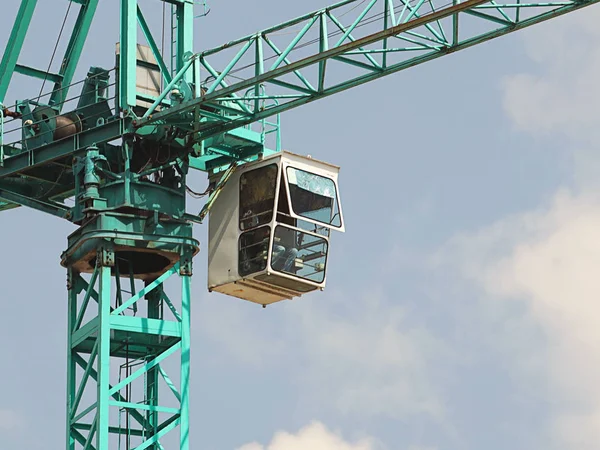 Gruas-torre trabalham durante a construção de um edifício de vários andares. Novos apartamentos para residentes e instalações para escritórios. Trabalho arriscado em altura. Levantamento de materiais de construção pesados. Desenvolvimento da cidade — Fotografia de Stock