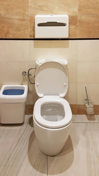 浴室内饰为浅米色和白色。椭圆形陶瓷厕所。需要男人的地方。城市基础设施公共区域的卫生间。公共空间内部 — 图库照片