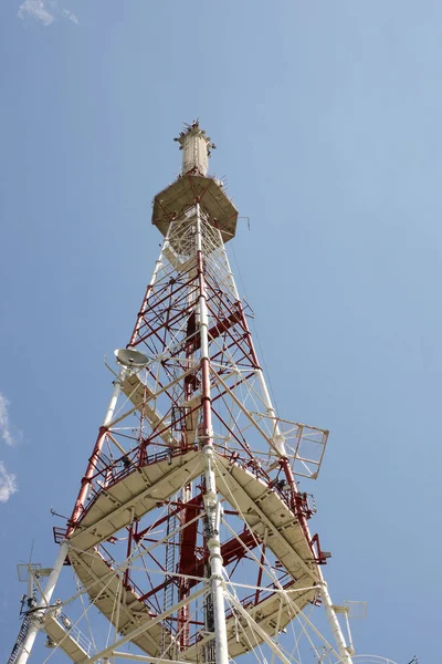 Uzaktan elektromanyetik sinyaller almak ve iletmek için radyo-televizyon kulesi. Metal yüksek teknoloji inşaat beyaz bir bulut içinde kefen. Darbe frekansının kaynağı. Lviv, Ukrayna