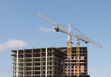 İnşaat yüksek kule kare metal vinç kullanımı. Mavi gökyüzüne karşı Kent panoraması. Emlak ve kentleşme çalışır. İş geliştirme metal konstrüksiyon