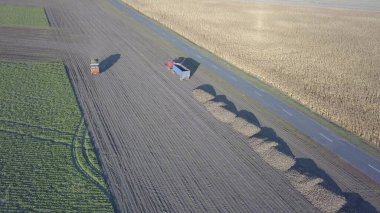 Şeker pancarı hasat ediyorum. Kombine ve arabalar tarladan kök ekinleri topluyor. İnsansız hava aracı ya da kuadrokopterden yapılan hava taraması. Çiftlikte sonbahar tarlası işi. Şeker üretimi için hammadde hasat ediliyor