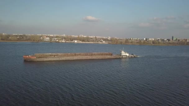 一艘拖船推动一艘驳船沿河上游运送散装材料 用四分机或无人驾驶飞机的空中摄影 第聂伯河全景 乌克兰的主要水运干线 — 图库视频影像