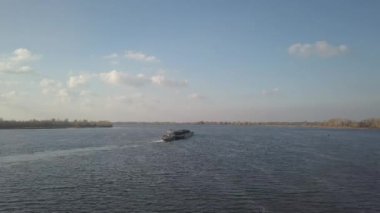 Bir römorkör gemisi, büyük malzemeleri taşımak için nehrin yukarısına bir mavna itiyor. Kuadkopterli ya da dronlu hava fotoğrafçılığı. Dinyeper Panoraması - Ukrayna 'nın ana su nakil atardamarı.