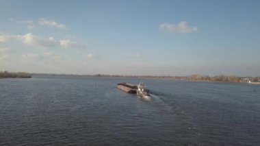 Bir römorkör gemisi, büyük malzemeleri taşımak için nehrin yukarısına bir mavna itiyor. Kuadkopterli ya da dronlu hava fotoğrafçılığı. Dinyeper Panoraması - Ukrayna 'nın ana su nakil atardamarı.