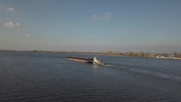 一艘拖船推动一艘驳船沿河上游运送散装材料 用四分机或无人驾驶飞机的空中摄影 第聂伯河全景 乌克兰的主要水运干线 — 图库视频影像