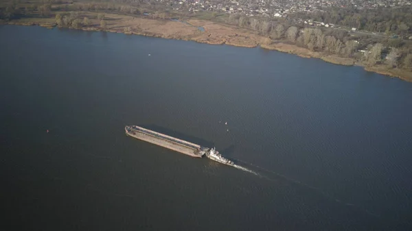 Ett bogserfartyg skjuter en pråm uppströms floden för att transportera bulkmaterial. Flygfoto med en quadcopter eller en drönare. Panorama av Dnepr - den viktigaste sjötransport artär i Ukraina — Stockfoto