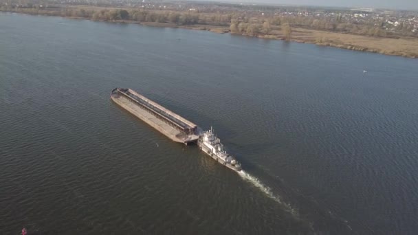 En slæbebåd skib skubber en pram opstrøms for floden til at transportere bulk materialer. Luftfotografering med en quadcopter eller en drone. Panorama of te Dnieper - den vigtigste vandtransport arterie i Ukraine – Stock-video