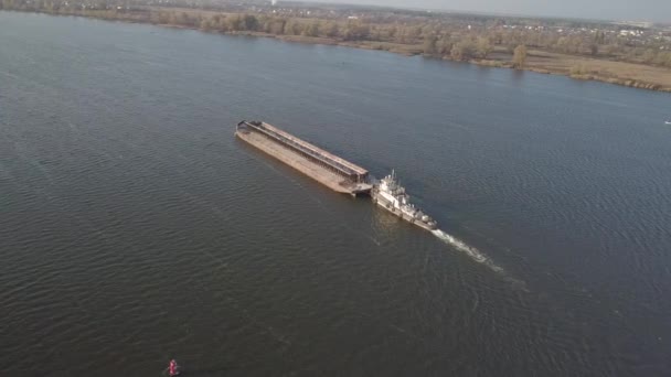 タグボート船は川の上流でバージを押してバルク材料を輸送する。四辺形やドローンを使った空中写真。ドニエプルのパノラマ-ウクライナの主な水輸送動脈 — ストック動画