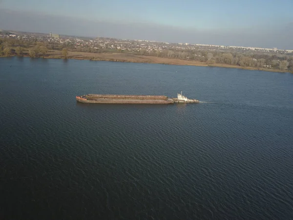 タグボート船は川の上流でバージを押してバルク材料を輸送する 四辺形やドローンを使った空中写真 ドニエプルのパノラマ ウクライナの主な水輸送動脈 — ストック写真